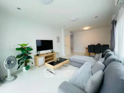 Spacious modern living room with large sectional sofa and wall-mounted TV, perfect for relaxation.