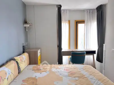 Cozy bedroom with modern decor and natural light, featuring a stylish desk and comfortable chair.