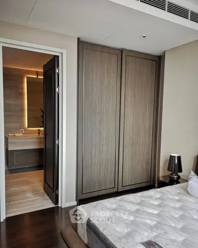 Modern bedroom with ensuite bathroom and sleek wooden wardrobe