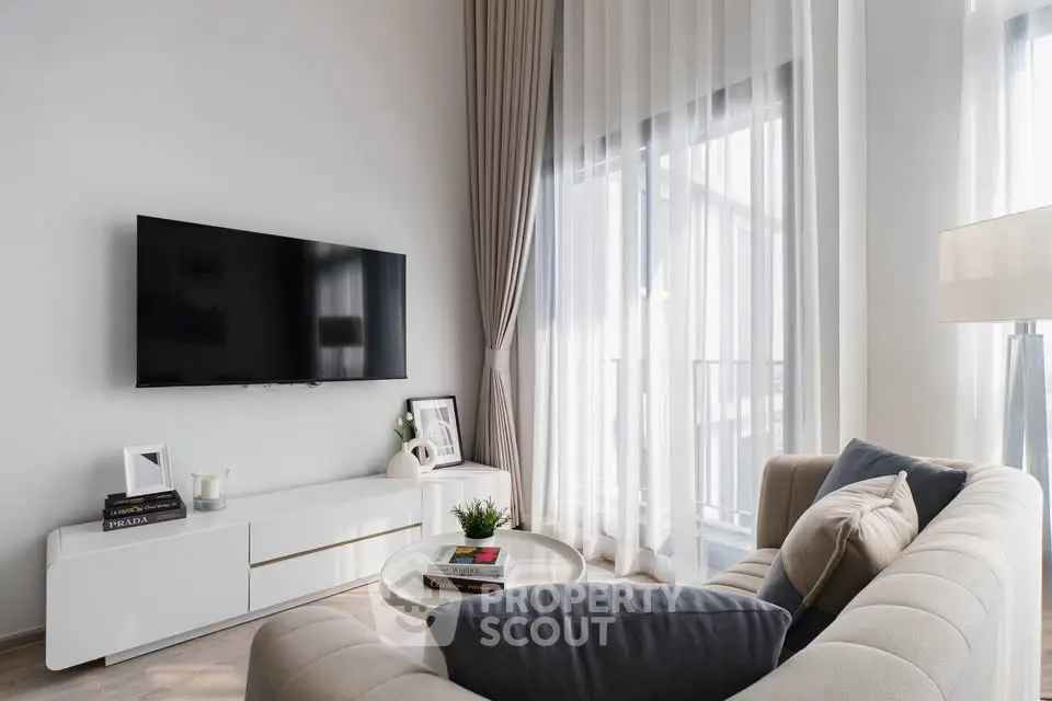 Modern living room with elegant decor and large windows for natural light.