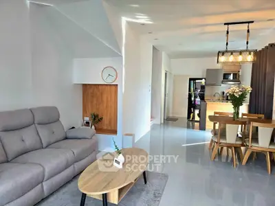 Modern open-plan living room with stylish furniture and kitchen area, perfect for contemporary living.