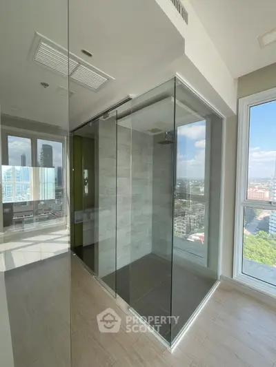 Modern bathroom with glass shower and city view in high-rise apartment