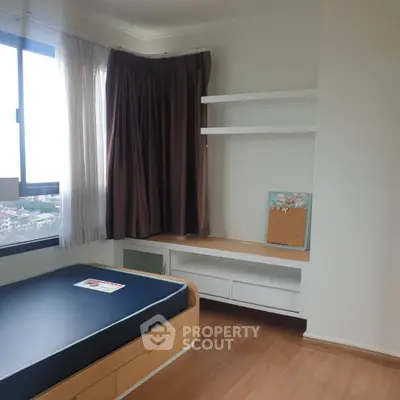 Modern bedroom with built-in shelves and large window offering natural light