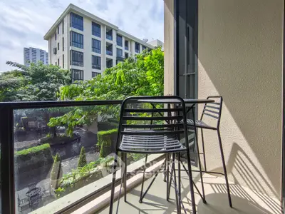 Charming balcony with modern seating and lush garden view in urban setting
