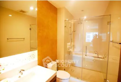 Modern bathroom with glass shower and elegant fixtures in a luxurious real estate property.
