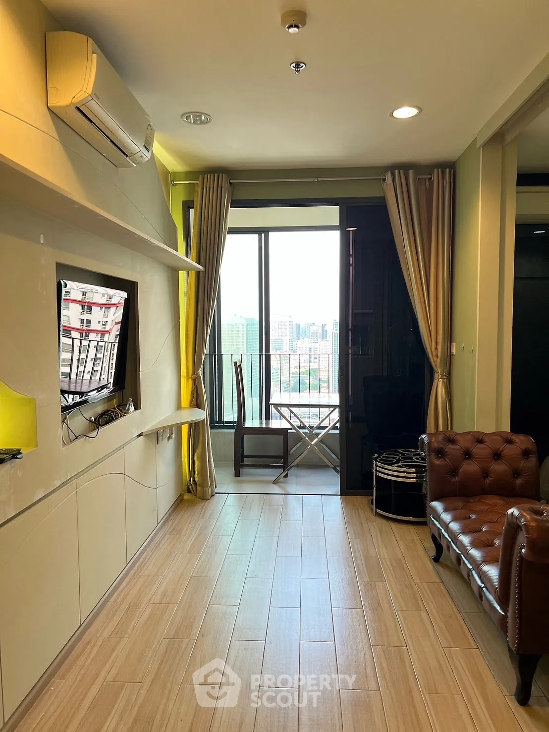 Modern living room with balcony view, featuring stylish furniture and ample natural light.