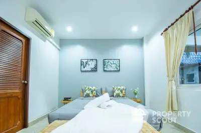 Cozy bedroom with modern decor and air conditioning, featuring a comfortable bed and stylish wall art.