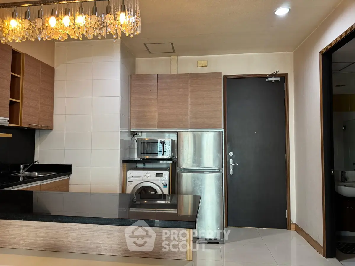 Modern kitchen with sleek appliances and stylish lighting in a contemporary apartment.