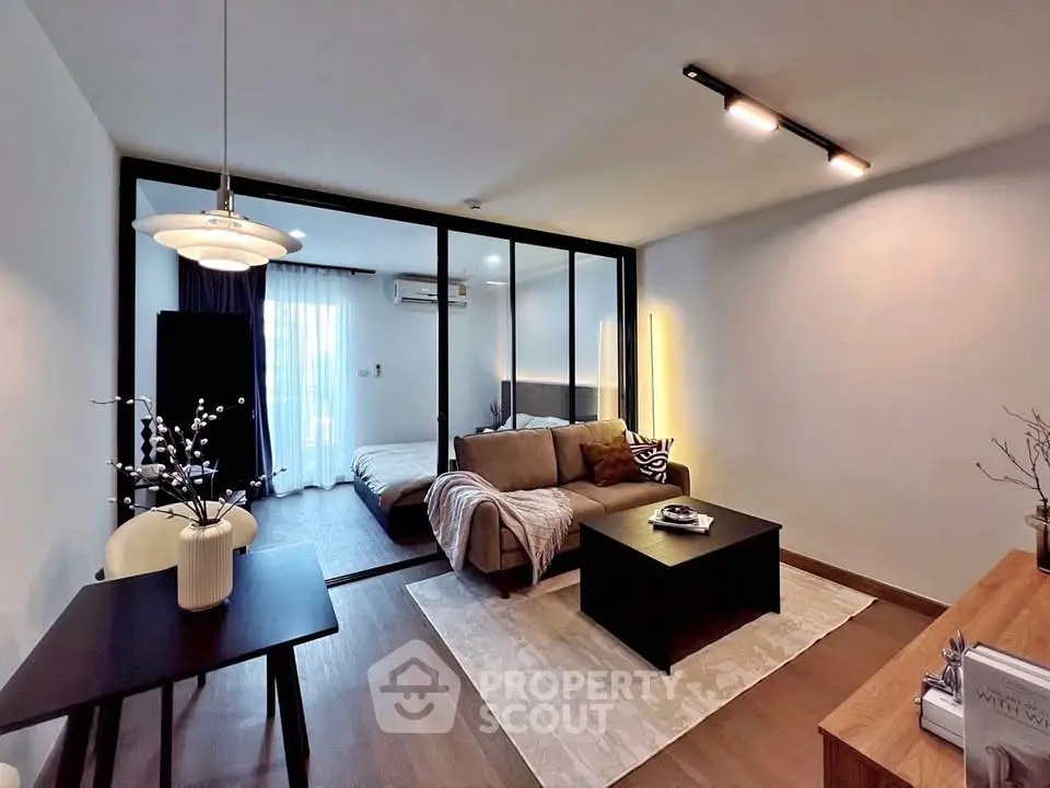 Modern living room with cozy seating and stylish decor in open layout apartment.