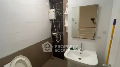 Compact bathroom with shower and sink in modern apartment