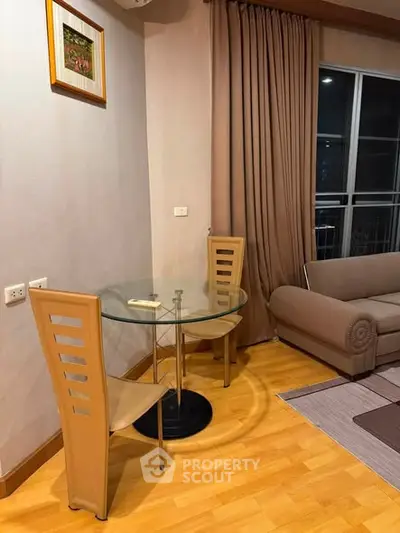 Cozy living room with modern furniture and glass table, perfect for relaxation and entertaining.