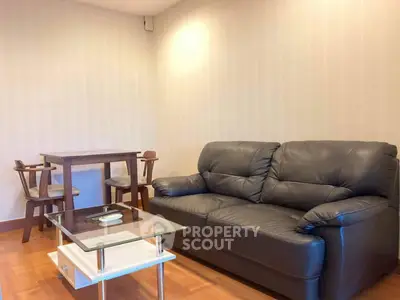 Cozy living room with leather sofa and modern dining set, perfect for relaxation and entertaining.
