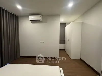 Modern bedroom with sleek design, featuring air conditioning and ample closet space.