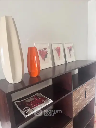 Stylish modern shelving unit with decorative vases and framed art in a contemporary living space.