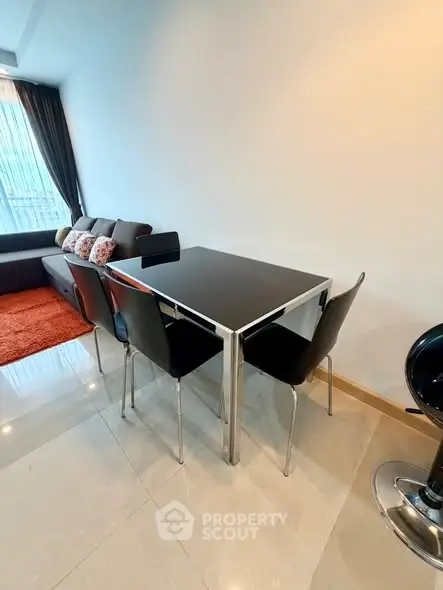Modern living room with sleek dining table and cozy sofa, perfect for urban living.