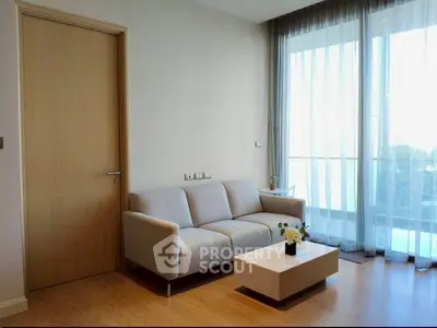 Modern living room with cozy sofa and natural light from large window