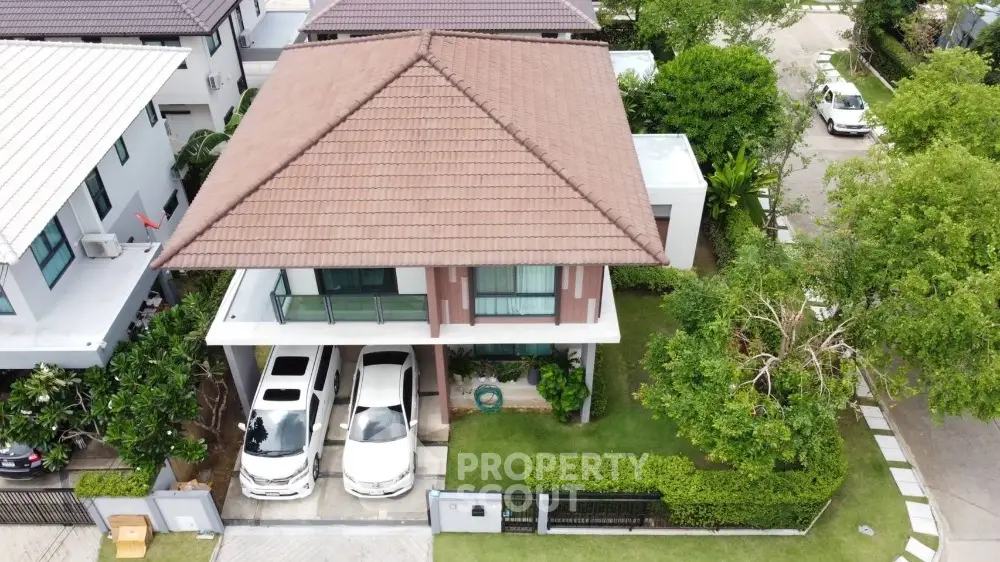 Modern two-story house with spacious driveway and lush green garden