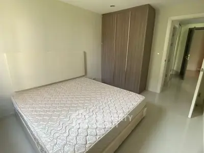 Spacious bedroom with modern wardrobe and comfortable mattress in a bright apartment.