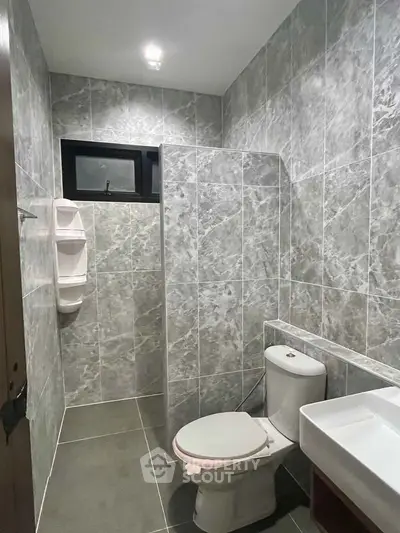 Modern bathroom with sleek gray tiles and compact design