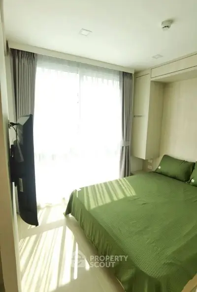 Bright and cozy bedroom with green bedding and natural light