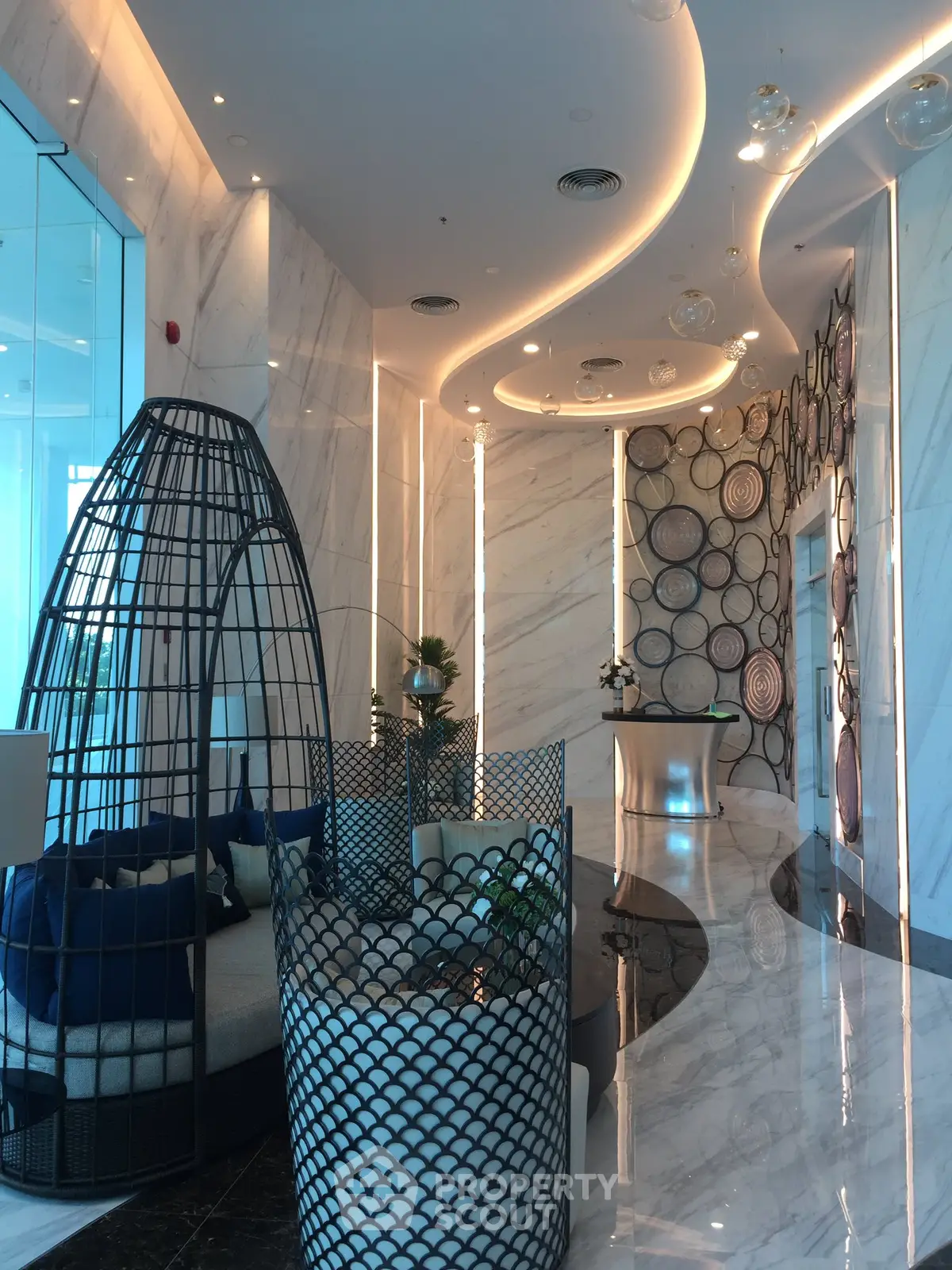 Luxurious modern lobby with elegant seating and artistic wall design in a high-end building.