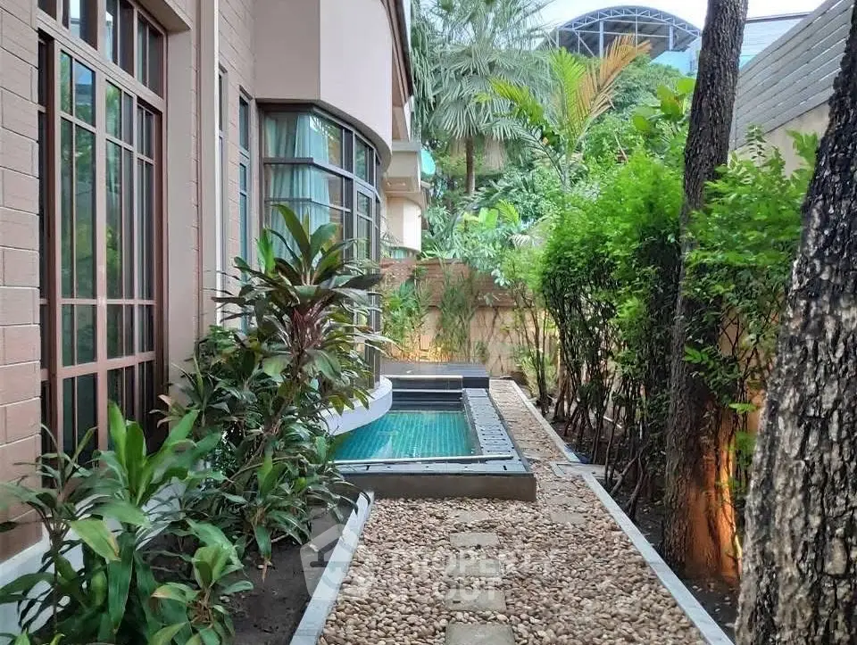 Charming garden view with small pool and lush greenery in a serene residential setting.