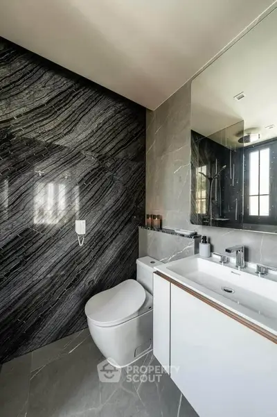 Luxurious modern bathroom with sleek marble accents and contemporary fixtures.