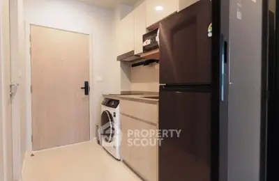 Modern kitchen with sleek appliances and washing machine in compact layout