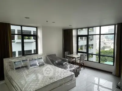 Spacious bedroom with large windows offering city views in modern apartment