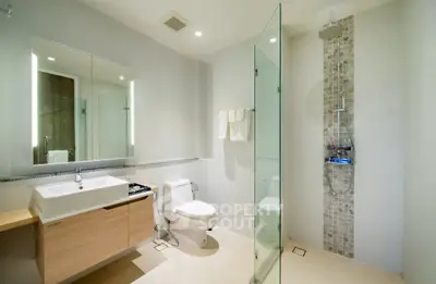 Modern bathroom with glass shower and sleek vanity in luxury home.