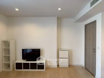Modern minimalist living room with TV and storage units, featuring sleek wooden flooring and recessed lighting.