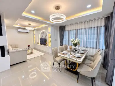 Luxurious open-plan living and dining area with elegant decor and modern lighting.