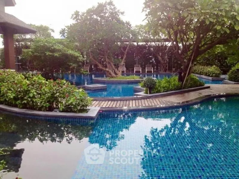 Luxurious outdoor pool surrounded by lush greenery and serene ambiance.
