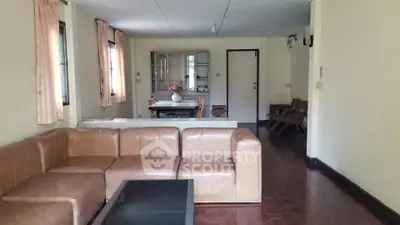 Spacious living room with modern leather sofa and dining area in open layout