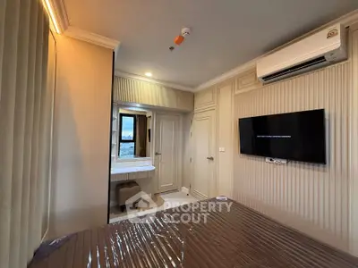 Modern bedroom with wall-mounted TV and air conditioning in a stylish apartment.