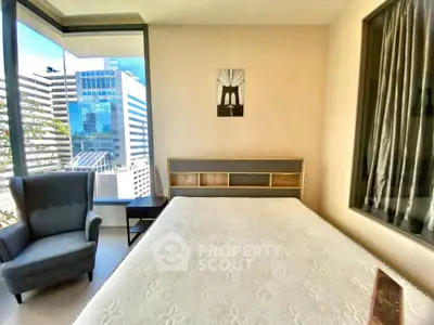 Modern bedroom with large windows offering stunning city views, featuring a cozy armchair and minimalist decor.