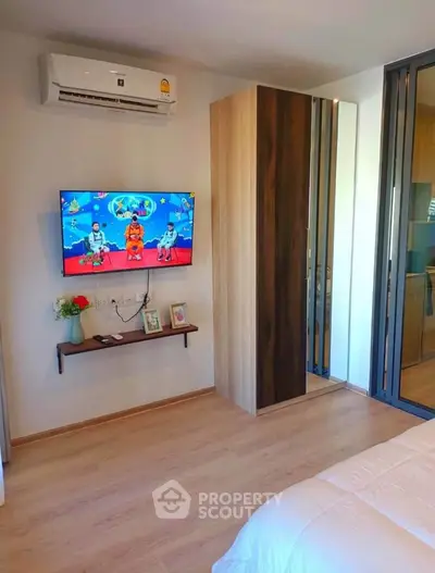 Modern bedroom with wall-mounted TV and sleek wardrobe design