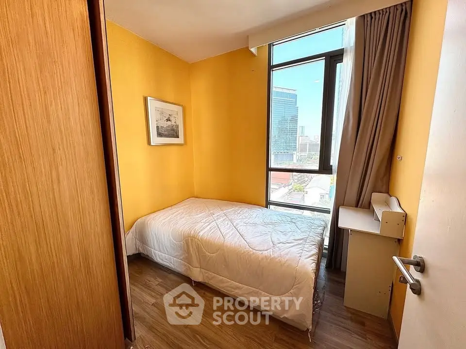 Cozy bedroom with bright yellow walls and city view window