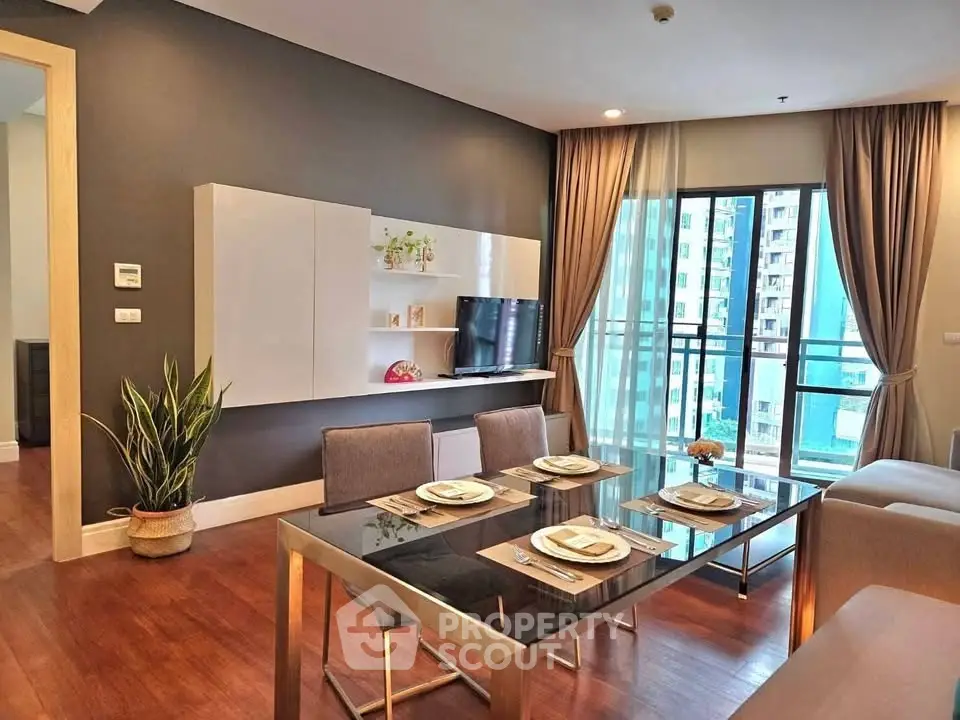 Modern living room with dining area and city view, featuring sleek furniture and elegant decor.
