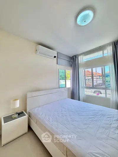 Bright and airy bedroom with large windows and modern furnishings