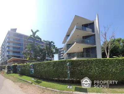 Modern apartment buildings with lush greenery and clear blue sky