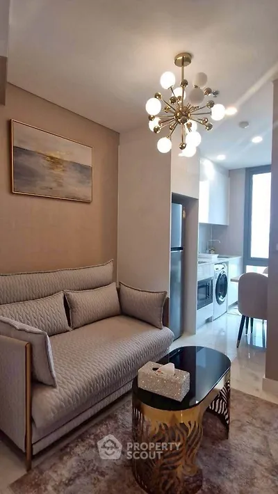Stylish living room with modern chandelier and cozy sofa in a contemporary apartment.
