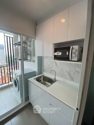Modern compact kitchen with balcony view and appliances