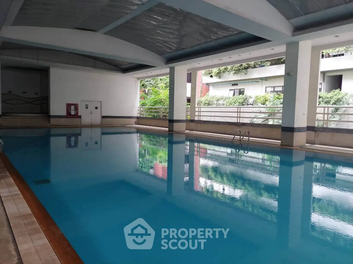 Luxurious indoor swimming pool with modern design and lush greenery view, perfect for relaxation and leisure.