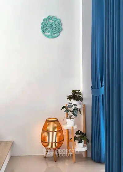 Stylish interior corner with blue curtains, decorative wall art, and modern lighting.