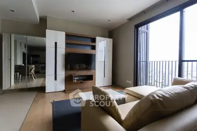 Modern living room with sleek furniture and large window offering city view