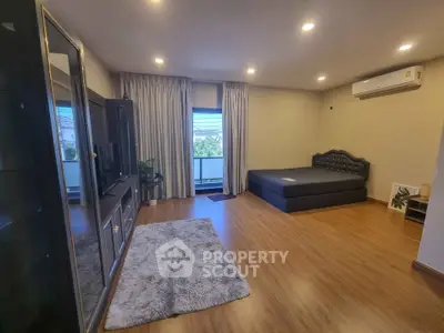 Spacious bedroom with modern furnishings and large window view