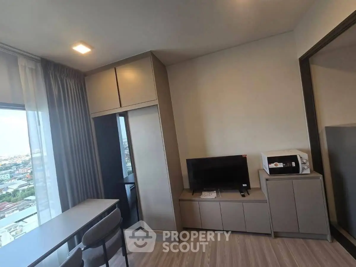 Modern living room with city view, sleek furniture, and natural light.