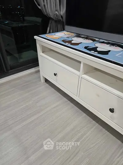 Modern living room with stylish TV stand and city view from window.