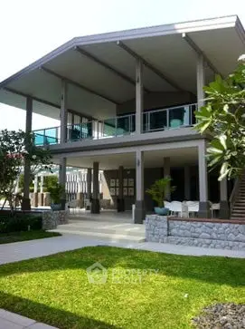 Stunning modern two-story home with spacious balcony and lush garden.
